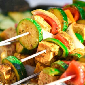 Colorful skewers stacked with grilled tofu, zucchini, bell peppers, and onions, seasoned with spices. This Race-Ready Kitchen creation promotes high-yield protein skewers for muscle protein synthesis.