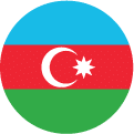 A circular flag icon of Azerbaijan displays horizontal blue, red, and green stripes with a white crescent and an eight-pointed star centered on the red stripe.