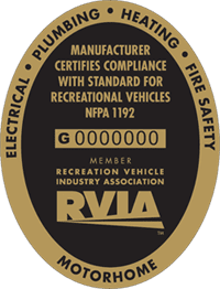 Oval certification label for recreational vehicles with gold border and black center. Text reads RVIA, NFPA 1192, and lists electrical, plumbing, heating, fire safety, and motorhome compliance. Serial number shown.